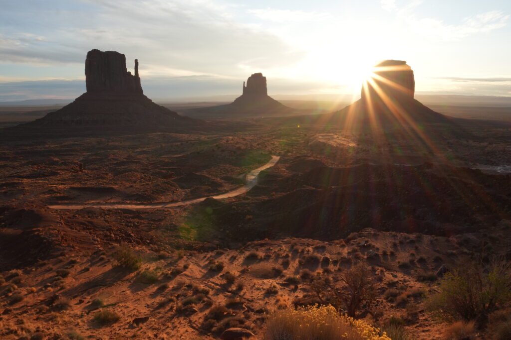 Sonnenaufgang im Monument Valley in den USA mit roten Felsformationen und weiter Wüstenlandschaft