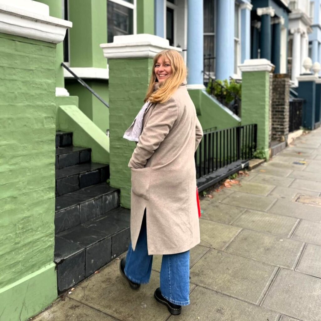 Janina vor den pastellfarbenen Häusern von Notting Hill in London – unterwegs für ihren Reiseblog.