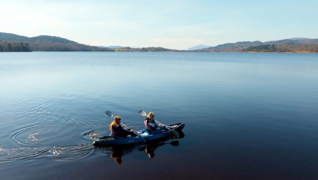 Kajaktour auf einem Loch in den schottischen Highlands mit Blick auf Berge und Natur